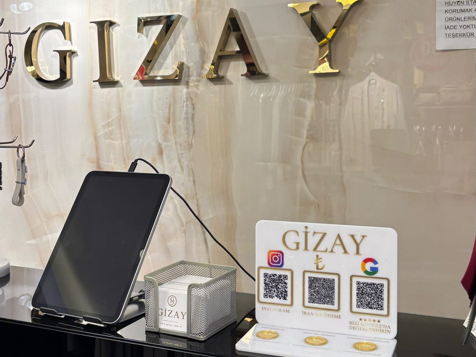 Gizay Giyim mağazasının kasasında kullanılan, Instagram, İBAN ile ödeme ve Google yorum için QR ve NFC alanlı özel tasarım pleksi stand